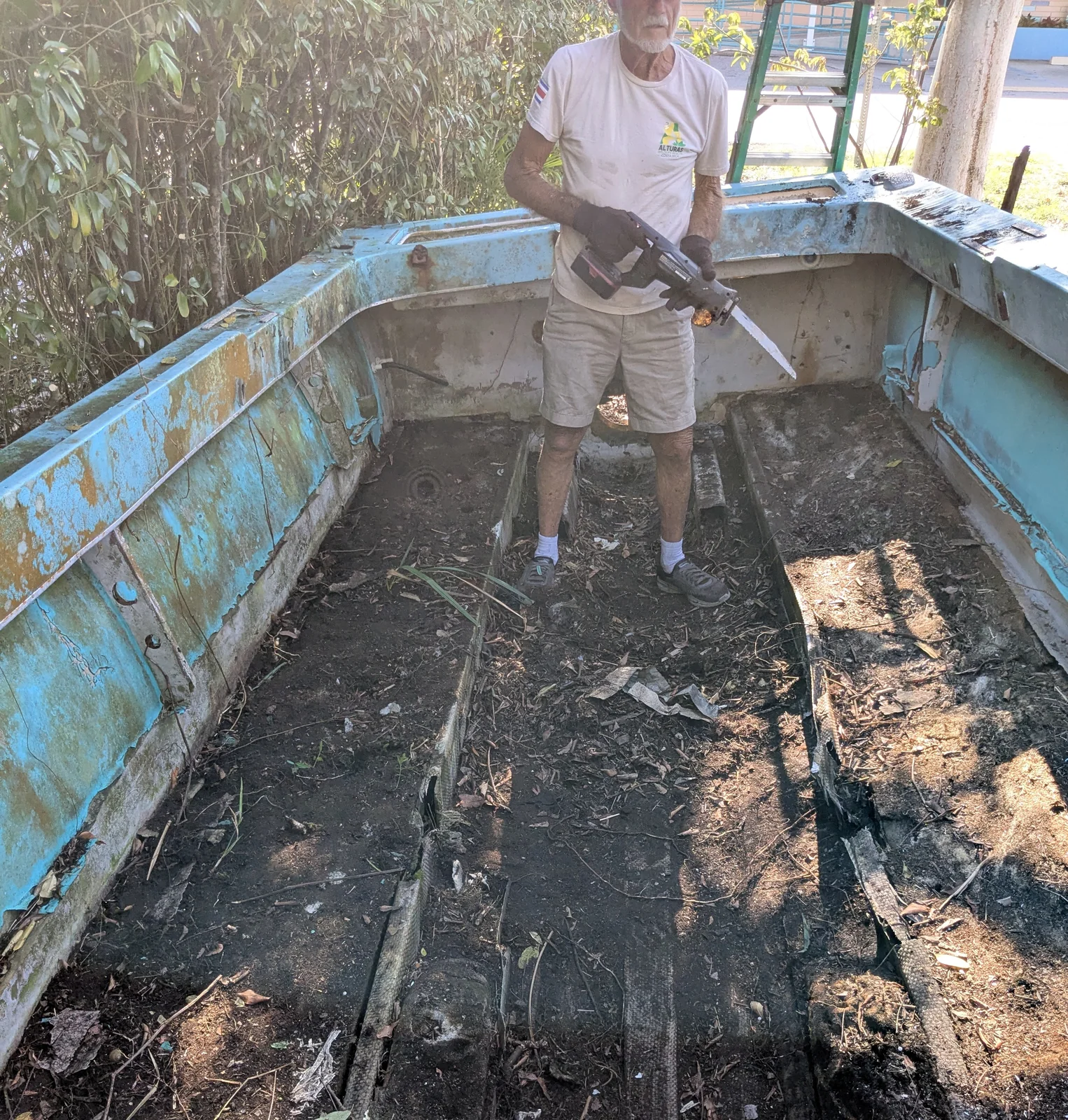 jim-freeman-cutting-rot-margood-boat Jim Freeman using a reciprocating saw to cut rotted material from the interior of the Mar-Good boat in Goodland